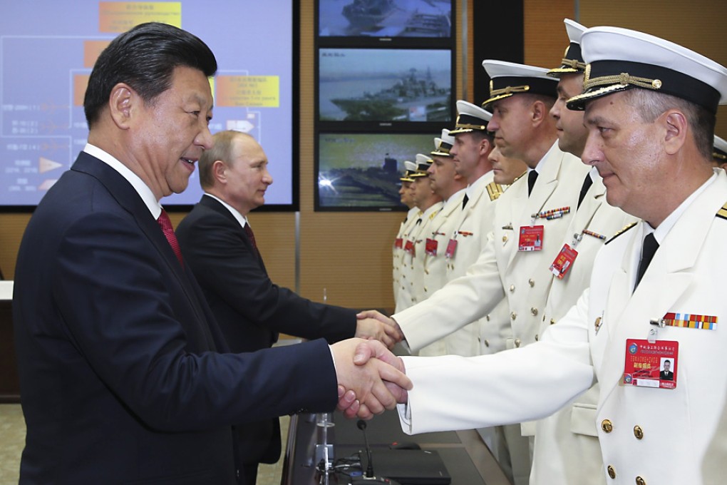 Chinese President Xi Jinping (left) and his Russian counterpart Vladimir Putin shake hands with members of the naval forces from both sides before the launch ceremony of the China-Russia Joint Sea-2014 exercise at Wusong naval port in Shanghai. Photo: Xinhua