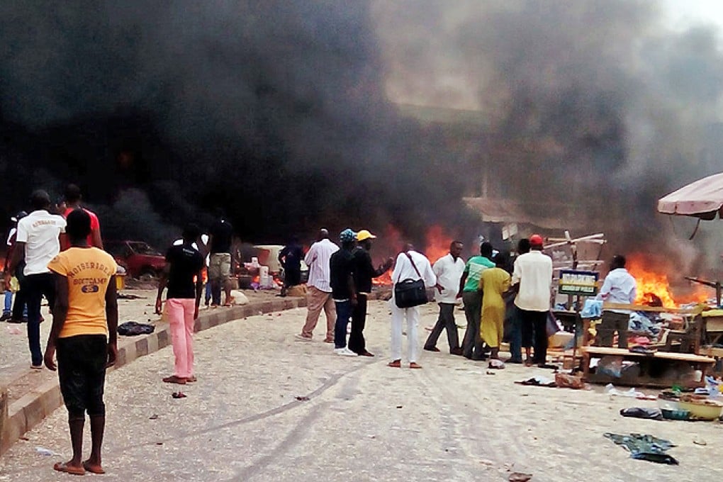Smoke rises after one of the bomb blasts at a bus terminal in Jos. Photo: AP