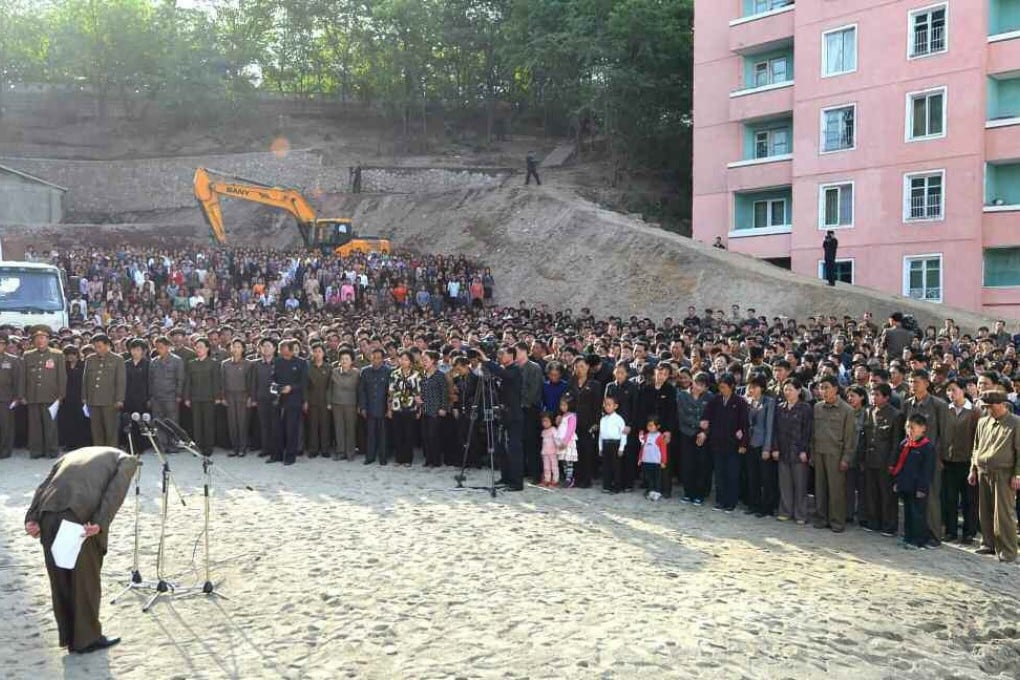 North Korean official (left) bows in apology to citizens over an apartment building collapse at a construction site in Pyongyang. Photo: EPA