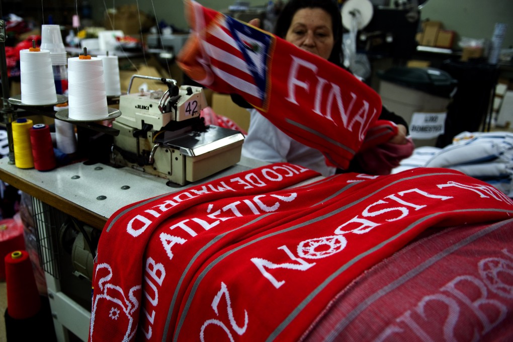 A textile worker in northern Portugal sews Atletico Madrid scarves. Ahead of Saturday's Champions League final, the company has manufactured around 30,000 official Atletico scarves. Photo: AP
