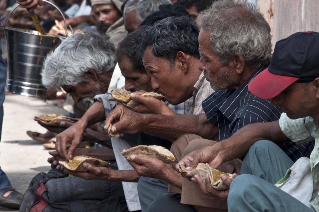 Homeless men tuck into a meal provided by local traders and citizens in Delhi where the gap between rich and poor is growing. Photo: AFP