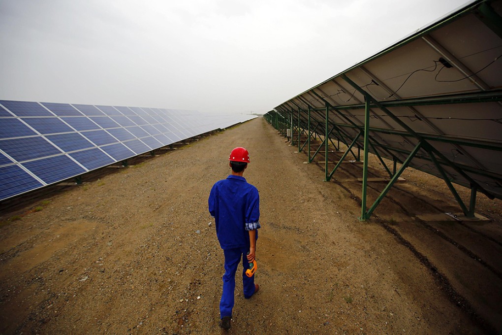 A worker inspects solar panels at a solar farm in Dunhuang. Photo: Reuters