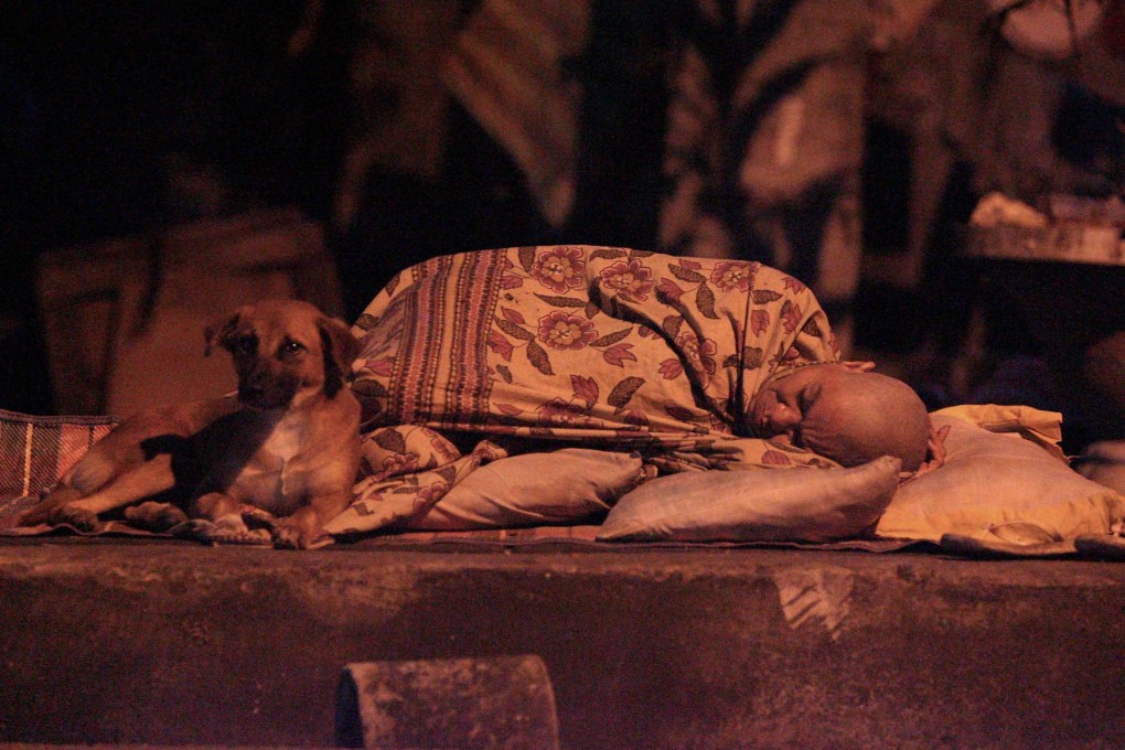 A homeless Filipino sleeps in a roadside gutter in Manila.Photo: EPA