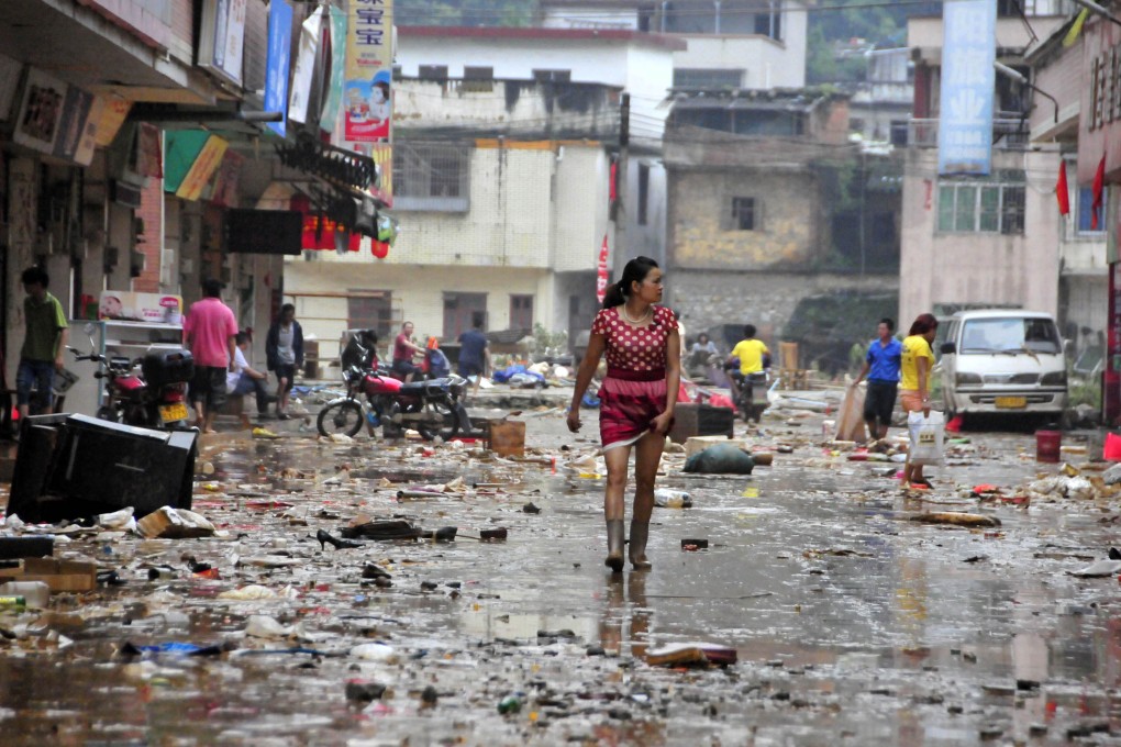 Residents walk on a street after flooding in Shitan town of Qingyuan, south China's Guangdong province. Photo: AP
