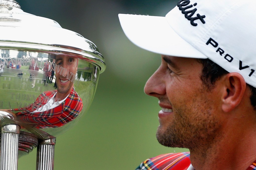 Adam Scott looks at his reflection in the trophy. Photo: AFP