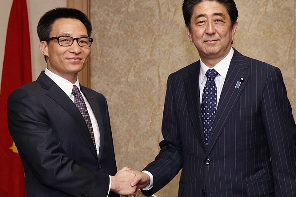 Japan's Prime Minister Shinzo Abe shakes hands with Vietnam's Deputy Prime Minister Vu Duc Dam. Photo: EPA