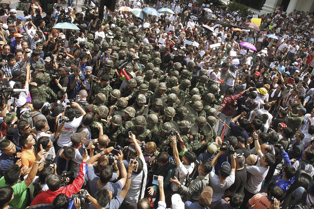 Thai soldiers are surrounded by protesters in Bangkok. The military may now become less tolerant towards demonstrators. Photo: AP