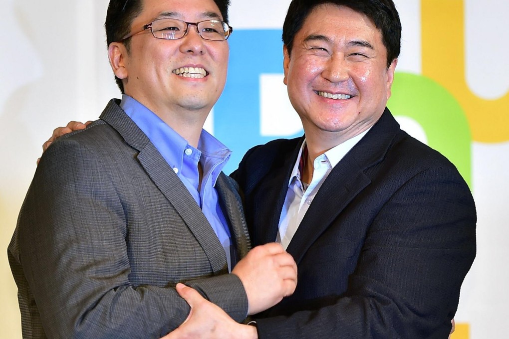 Daum's chief Choi Sae-hoon (left) and his counterpart at Kakao, Lee Sir-goo, announce their merger in Seoul yesterday. Photo: AFP