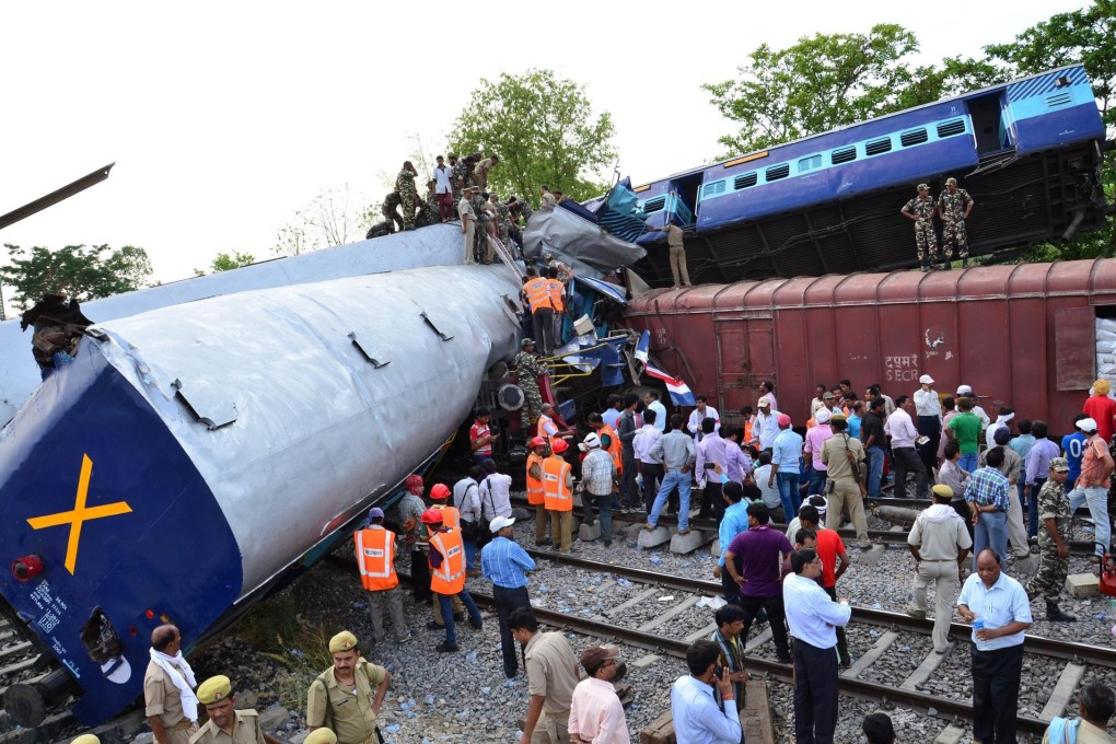 Rescuers search the mangled train compartments after the Gorakhdham Express rammed into a stationary train in Uttar Pradesh. Photo: AFP