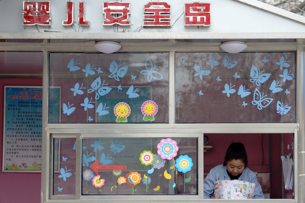 A welfare worker is seen through the window of a baby hatch in Xian, Shaanxi. Photo: Xinhua