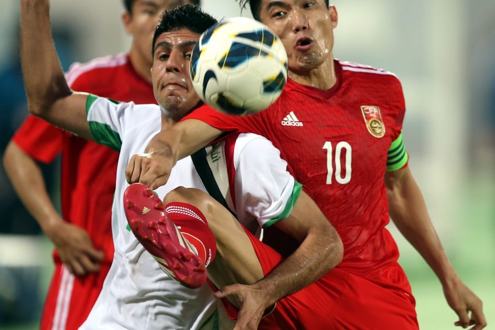 Zheng Zhi (right) fights for possession of the ball with Mohamad Karrar of Iraq during their qualifying match for the 2015 Asian Cupat Sharjah Stadium. Photo: EPA