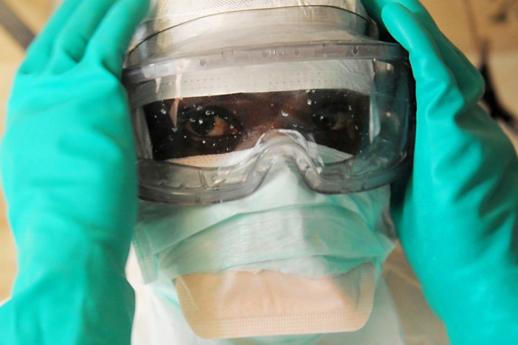 A health specialist prepares for work in an isolation ward for patients at a facility in Guinea. Photo: AFP