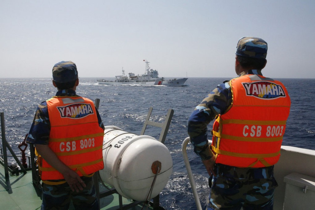 Officers of the Vietnamese Marine Guard monitor a Chinese coast guard vessel on the South China Sea, about 210 km offshore of Vietnam. Photo: Reuters