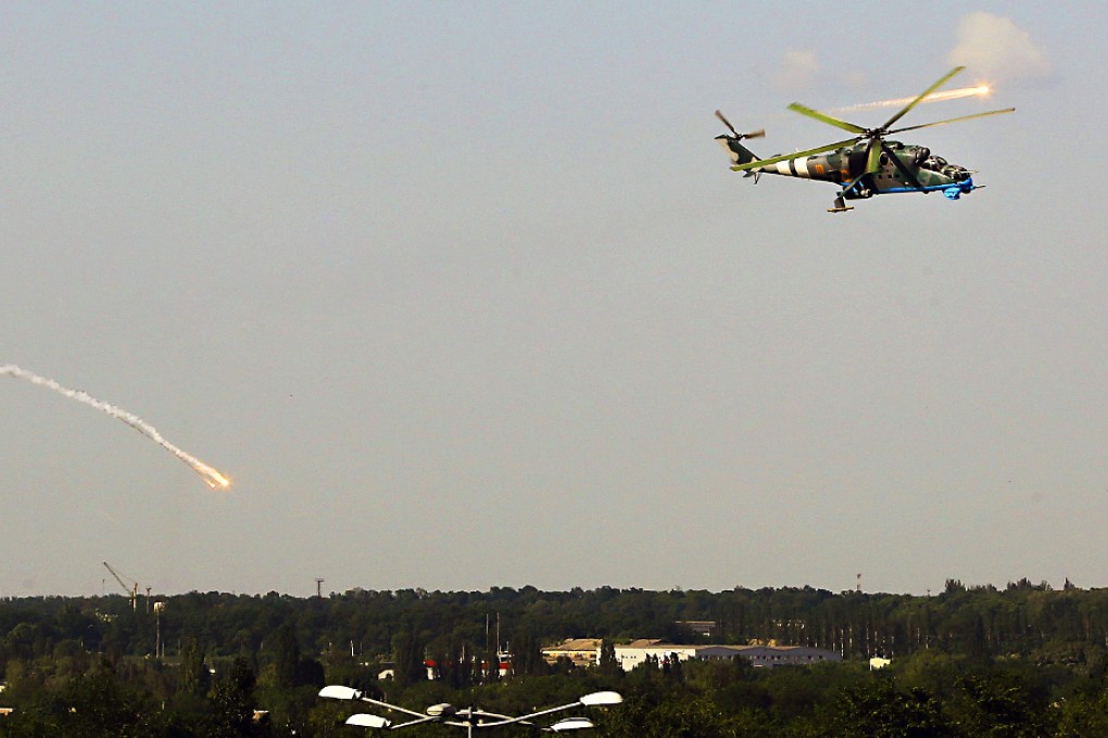 A Ukrainian helicopter gunship fires decoy flares over a residential area moments after attacking Donetsk international airport, while rebels shot down a Ukrainian military helicopter from . Photo: Reuters