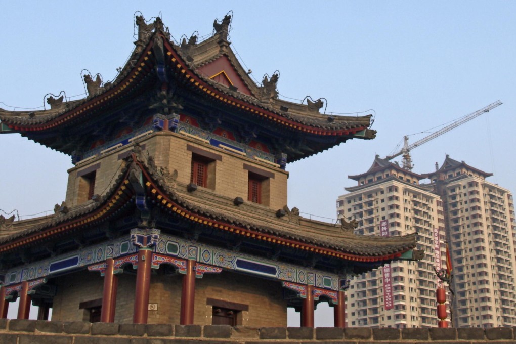 A watchtower in old Xian contrasts with a modern apartments, reflecting the city's role as hub for the new Silk Road. Photo: Bruce Holmes