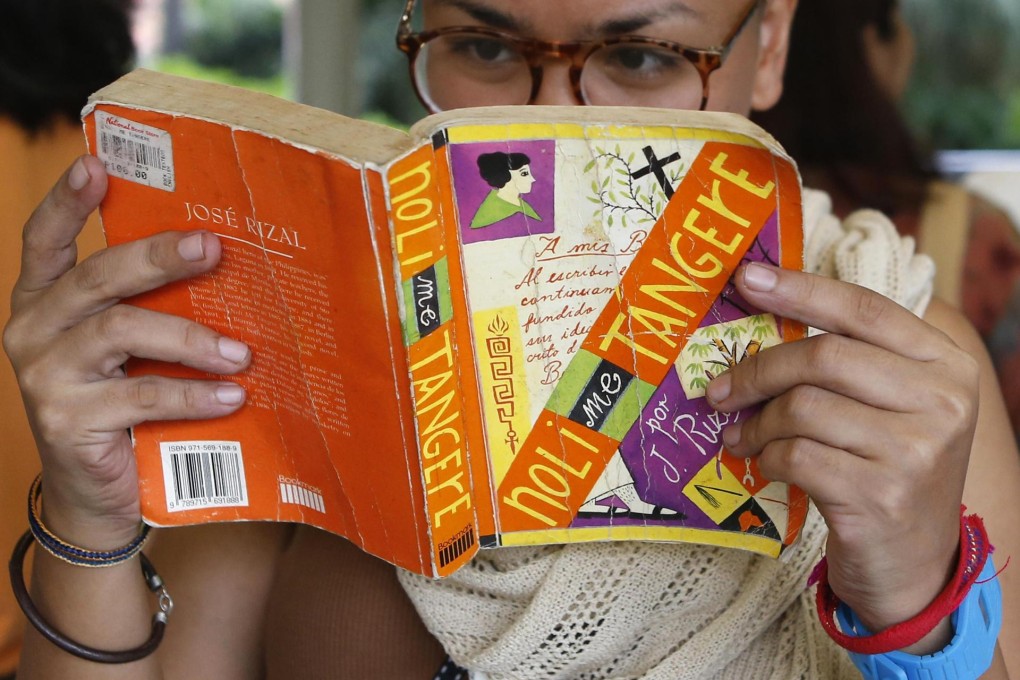 A protester reads an anti-colonial book written by a Philippine nationalist as a way to express discontent over the Thai coup. Photo: Reuters