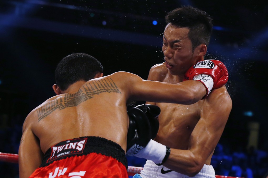 Rex “The Wonder Kid” Tso of Hong Kong recoils from a vicious right hook by Thailand's Ratchasak Kokietgym during their fight. Photo: AP
