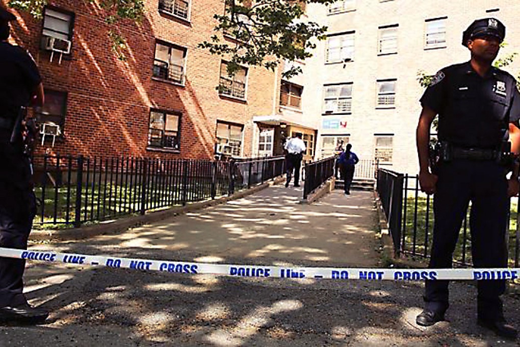 New York Police Department officers stand near the entrance to the building where the two children were attacked with a knife yesterday. Photo: AFP
