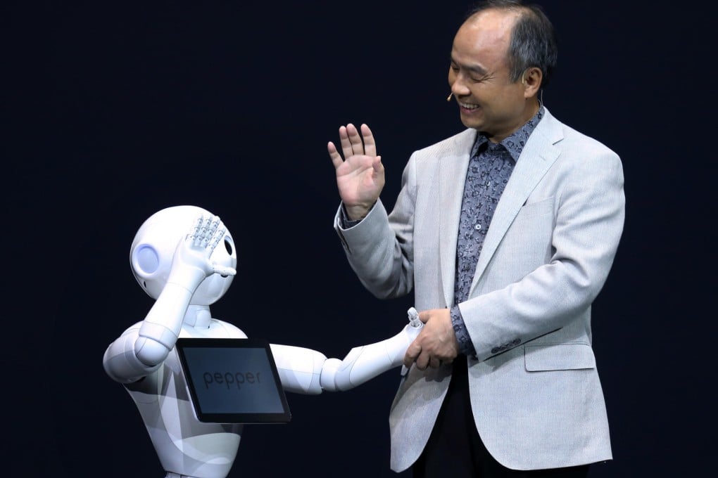 Masayoshi Son greets the human-like robot Pepper. Photo: Bloomberg
