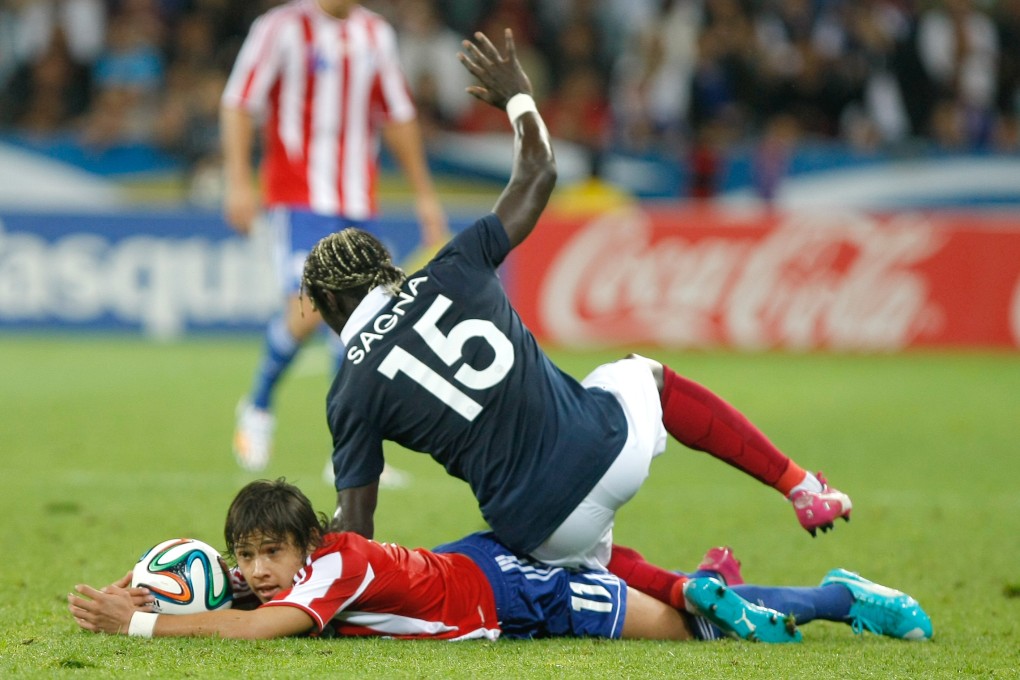 Bacary Sagna (right) challenges for the ball with Paraguayan midfielder Oscar David Romero Villamayor during their friendly in Nice. Photo: AP