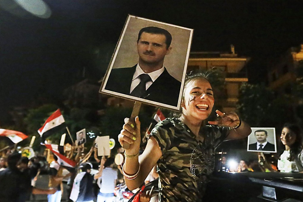 A girl holds a picture of Bashar a-Assad as she celebrates in Damascus after the poll win. Photo: AFP