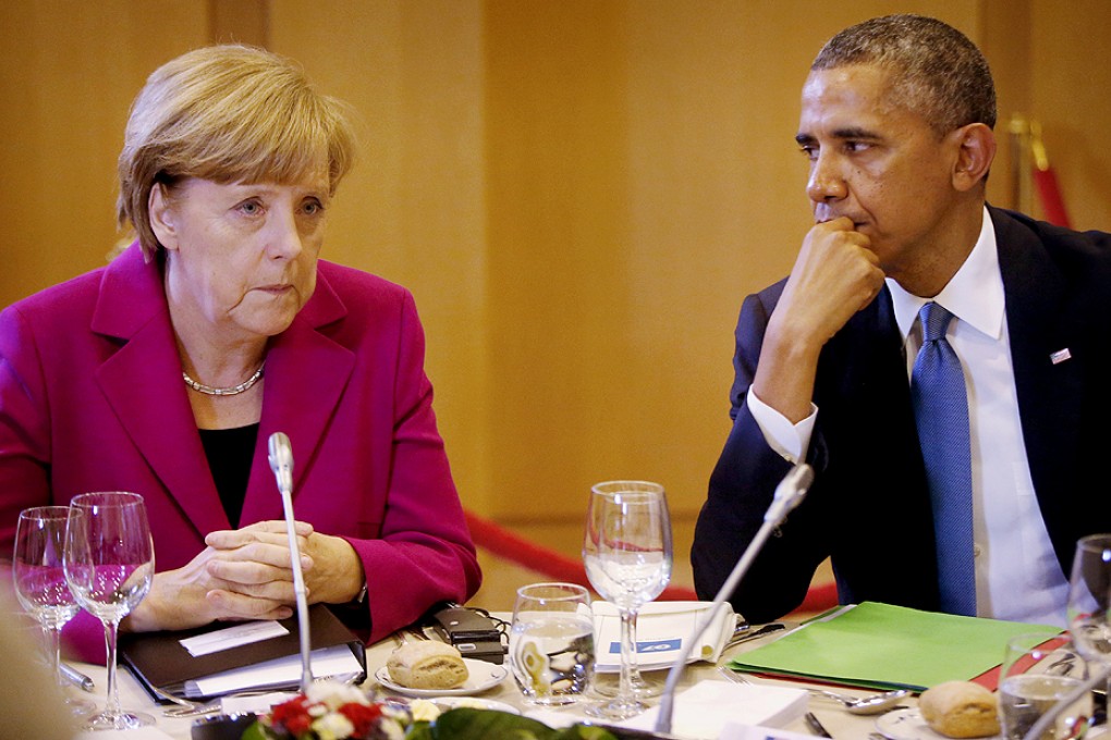 US President Barack Obama looks towards German Chancellor Angela Merkel as they participate in a G7 working dinner in Brussels on Wednesday. Photo: AP