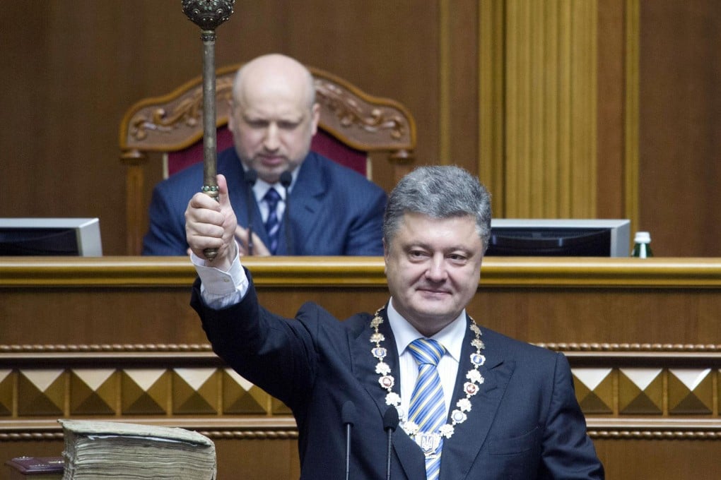 Petro Poroshenko holds up the presidential mace at his swearing-in before parliament. Photo: AFP
