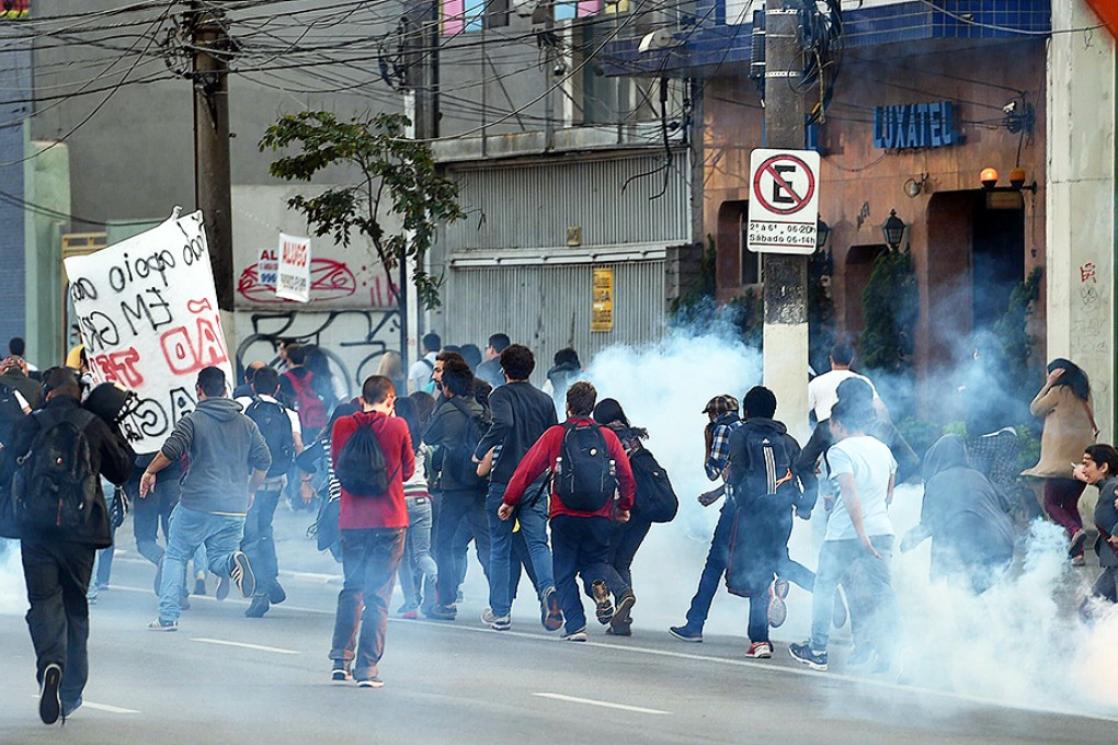 Striking subway workers and members of the Homeless Workers' Movement are dispersed with tear gas by police as they demonstrate in Sao Paulo. Photo: AFP