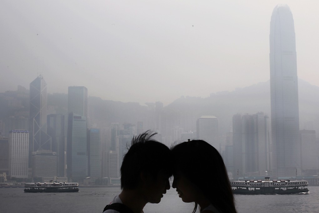 A couple enjoy themselves in Tsim Sha Tsui yesterday despite pollution levels that were described as posting a "serious risk" to health. A low pressure system was blamed for the smog that enveloped the city. Photo: Edward Wong
