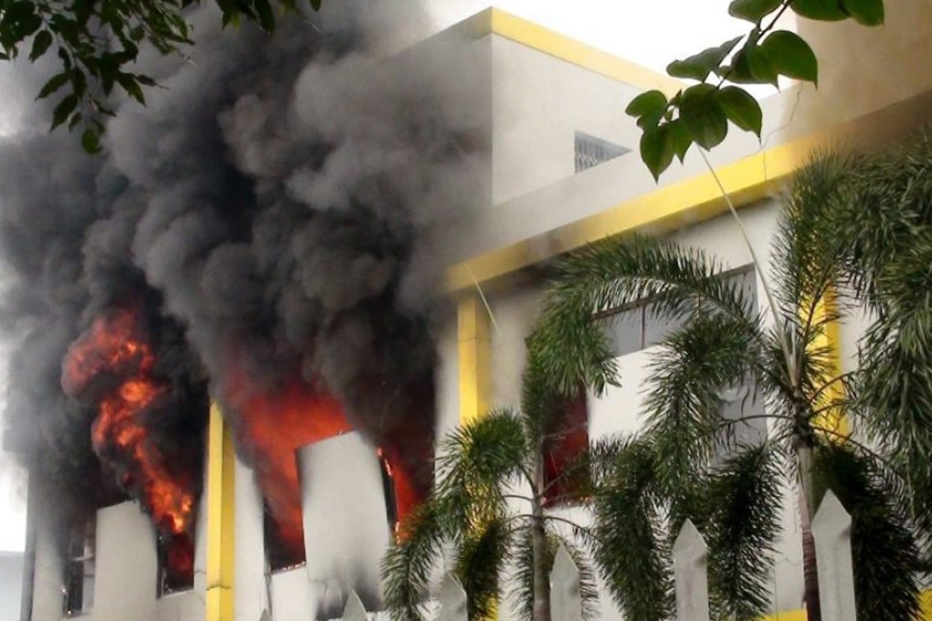 Smoke and flames billow from a building in a factory complex in Binh Duong province during the riots last month. Photo: EPA