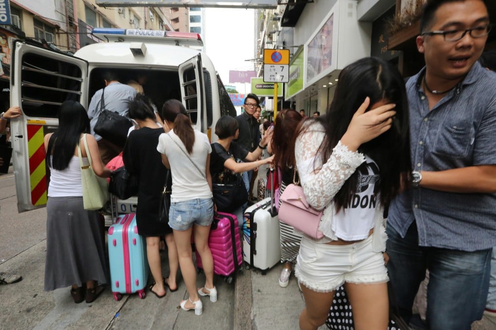 Police and immigration officers arrest suspected prostitutes from the mainland in raids on hotels yesterday. Photo: Felix Wong