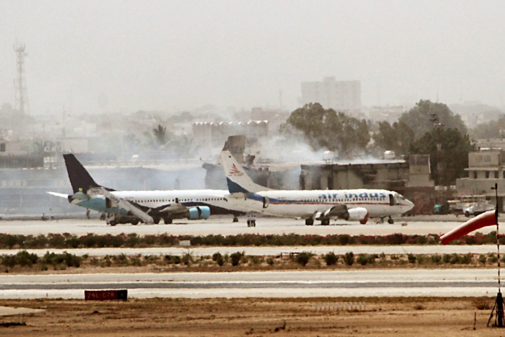 Smoke rises from buildings at Jinnah airport in Karachi on Tueday. Photo: EPA
