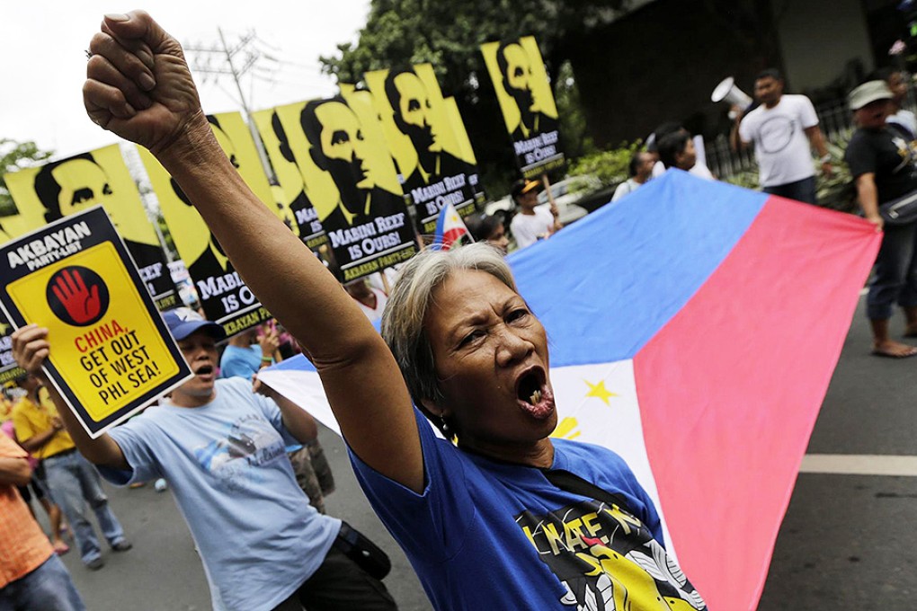 Protesters hold placards during a rally over the disputed Spratly Islands in front of the Chinese consulate office in Manila. Photo: EPA