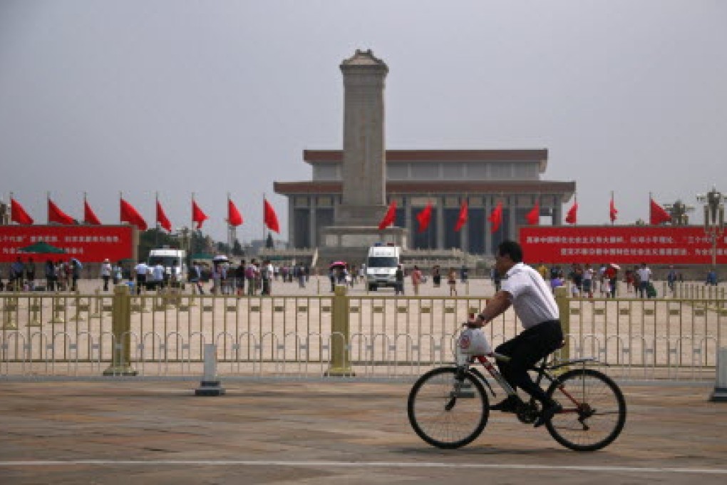 A man rides past the Monument to the People's Heroes at Tiananmen Square in Beijing. Photo: Reuters