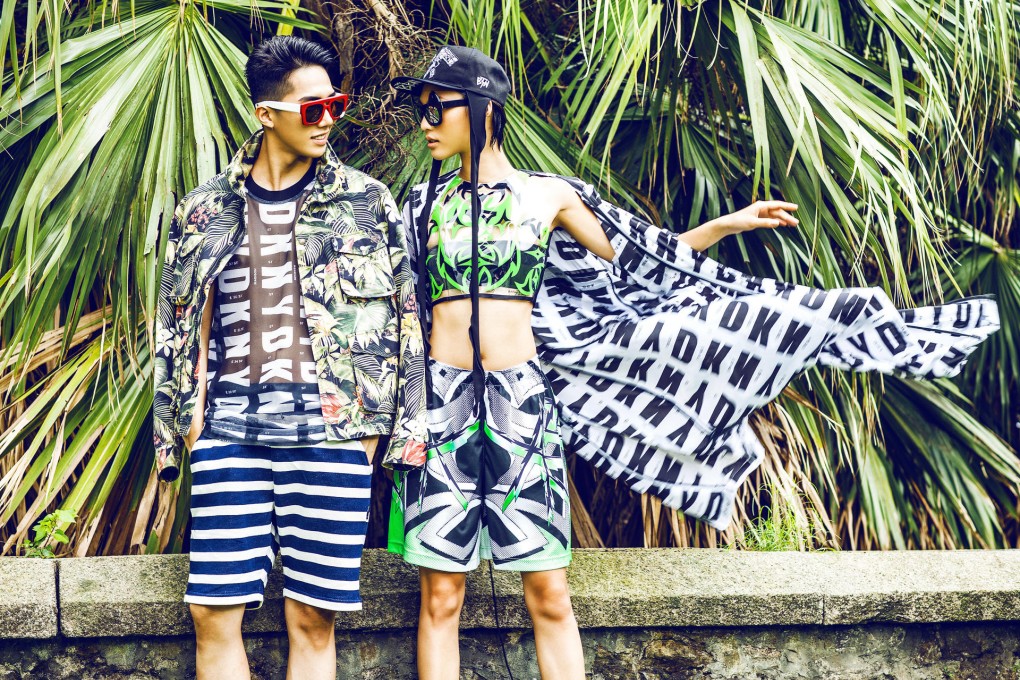 Yang Hoon wears a flower print jacket (HK$5,799) by Ami at I.T; logo scoop-neck tank top (HK$2,290) by DKNY; striped shorts (HK$399) by Izzue; red sunglasses (HK$2,750) by Numero at Lane Crawford. 
Xin Jie wears an HQ logo print anorak (HK$12,000) from DKNY; plastic crop top (HK$2,360); ninja print shorts (HK$1,630) by ASSK at Off the Wall; black skull embroidery double snapback (HK$2,360) by Kye at Off the Wall; black sunglasses (HK$2,900) by Revé by René at Woaw.