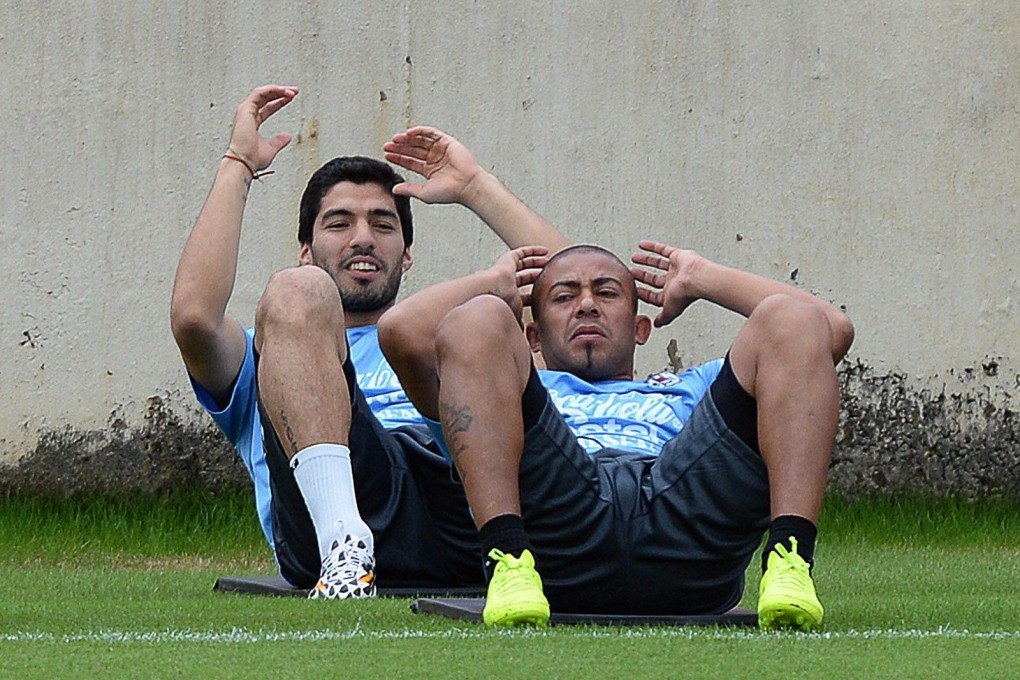 Uruguay striker Luis Suarez (left) and teammate Egidio Arevalo warm up for training in Sete Lagoas, Brazil. Photo: EPA