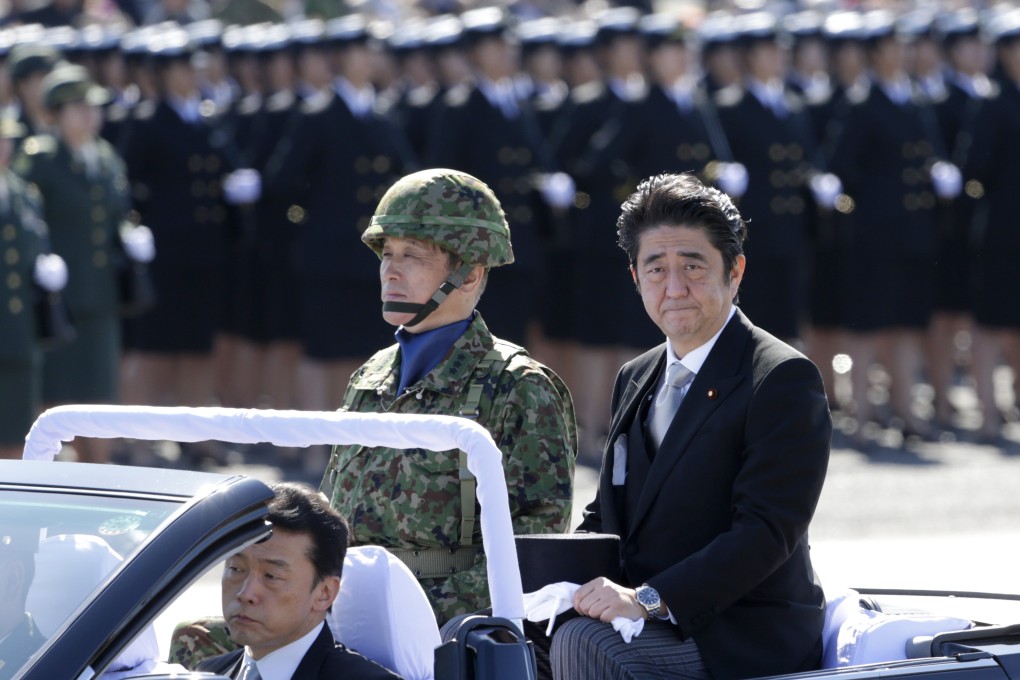 Prime Minister Shinzo Abe reviews members of Japan's Self-Defense Force (SDF) at Asaka Base, north of Tokyo, in September 2013. Photo: AP
