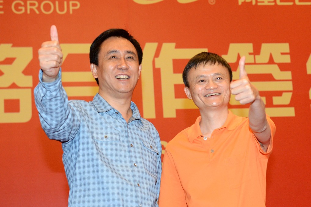 Evergrande Group chairman Xu Jiayin (left) and Alibaba founder and chairman Jack Ma give the thumbs up at a signing ceremony after Ma's e-commerce group became part owner of China's top soccer club. Photo: Xinhua