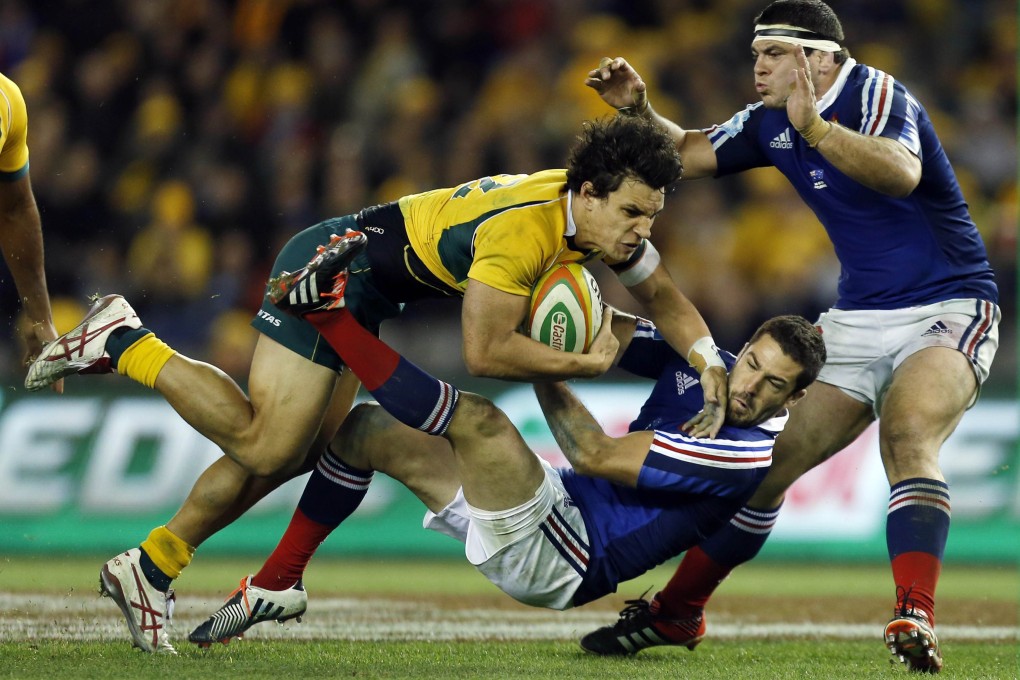 Wallaby Matt Toomua (left) runs over France's defence during their second rugby union test. Photo: Reuters