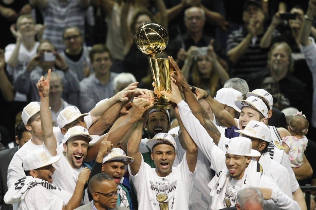San Antonio Spurs' Tony Parker hoists the Larry O'Brien trophy after his team defeated the Miami Heat. Photo: Reuters
