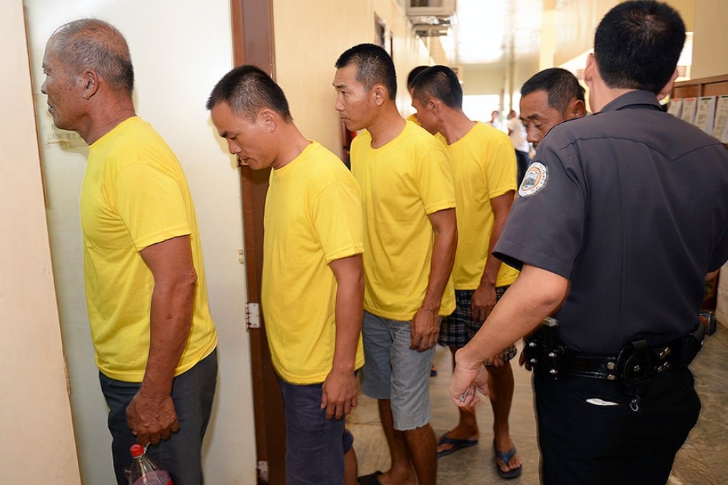 A Philippine prison guard escorts nine arrested Chinese fishermen as they arrive at a courtroom for a pre-trial in Puerto Princesa City, Palawan. Photo: AFP