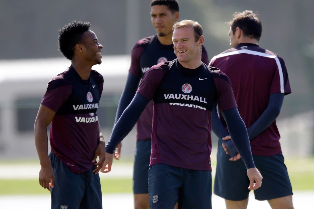 Raheem Sterling (left) and Wayne Rooney share a joke at an England training session. Photo: AP