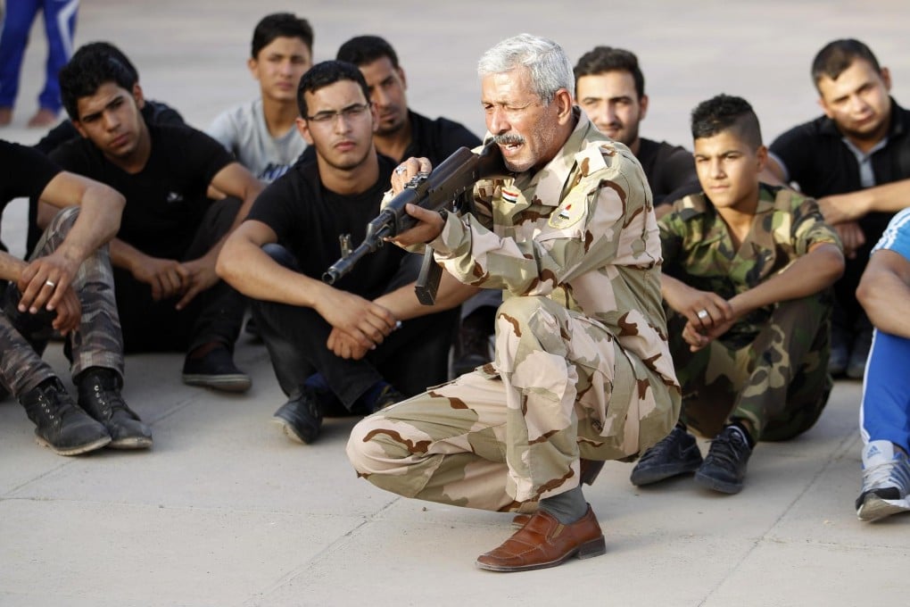 A fighter loyal to Shiite cleric Moqtada al-Sadr trains militiamen in Baghdad, as Sunni insurgents sweep across the country.Photo: Reuters