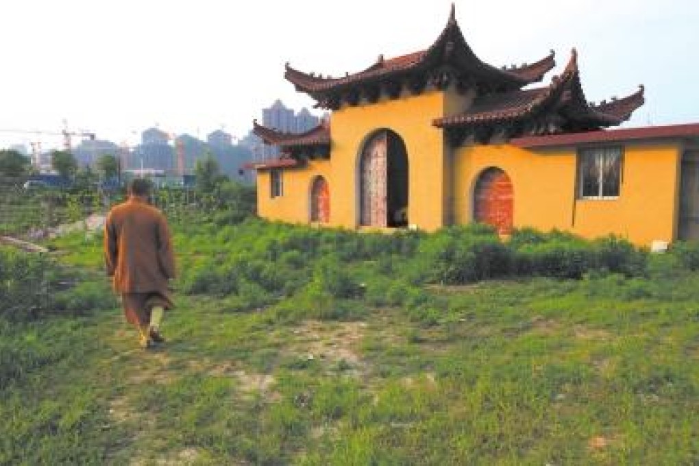 Abbott Kuan Xing of monastery Shiligusi stands in front of his monastery that only has its façade left. Photo: Xinhua