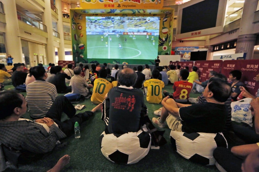Fans watch the opening match of the 2014 World Cup at a local mall.Photo: AP