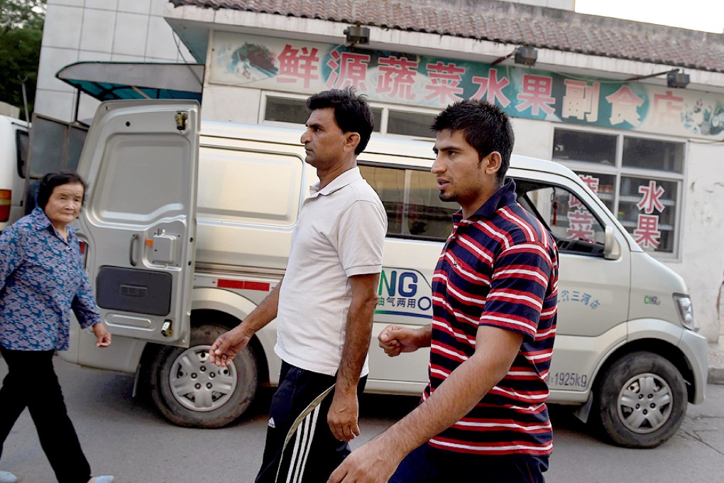 Pakistani refugees Waheed Ahmad and Ahsan Ahmad (right) walk through their apartment compound in Sanhe, in China's Hebei province. Muslim Ahmadis have abandoned their homes in Pakistan to find an unlikely refuge in China. Photo: AFP