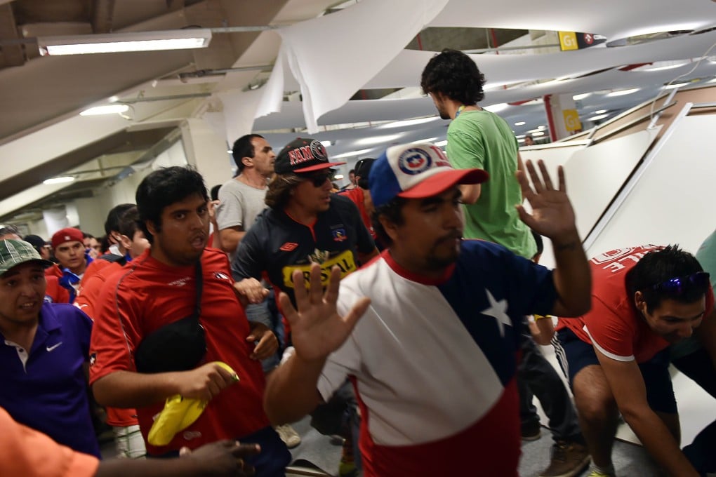 The fans crash through a partition. Photo: AFP