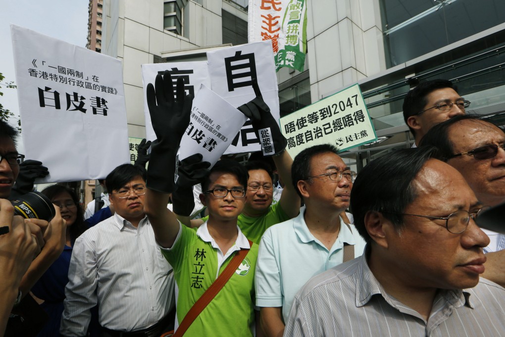 Protesters raise a mock white paper in a demonstration outside the central government's liaison office last week. Photo: AP
