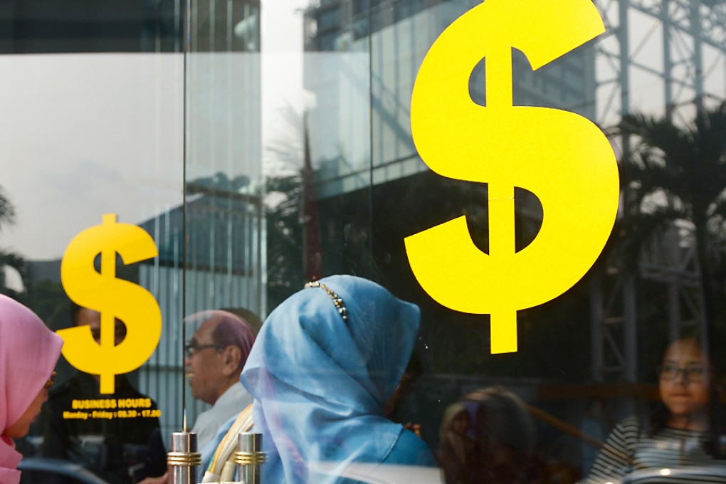 Indonesian customers (left) enter a money changer office in Jakarta. Photo: AFP