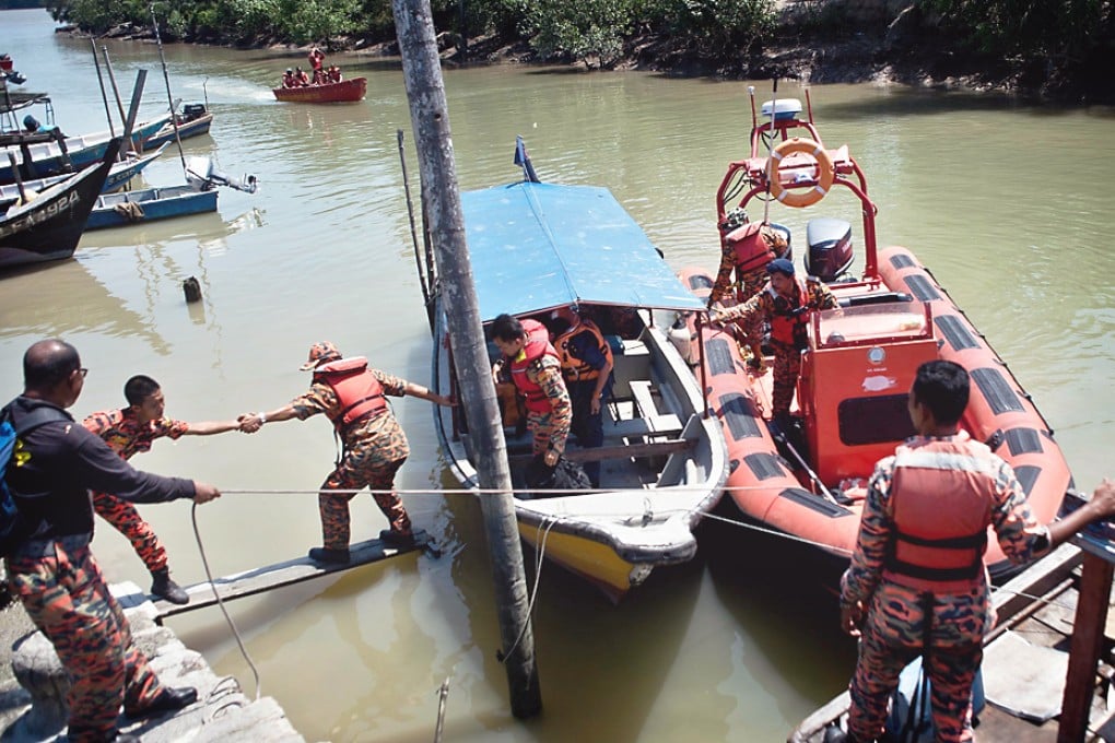 Malaysian search and rescue team disembark from a boat after returning from a rescue mission. Two were killed and 37 missing after an apparently overloaded boat carrying Indonesian illegal migrants sank off western Malaysia. Photo: AFP